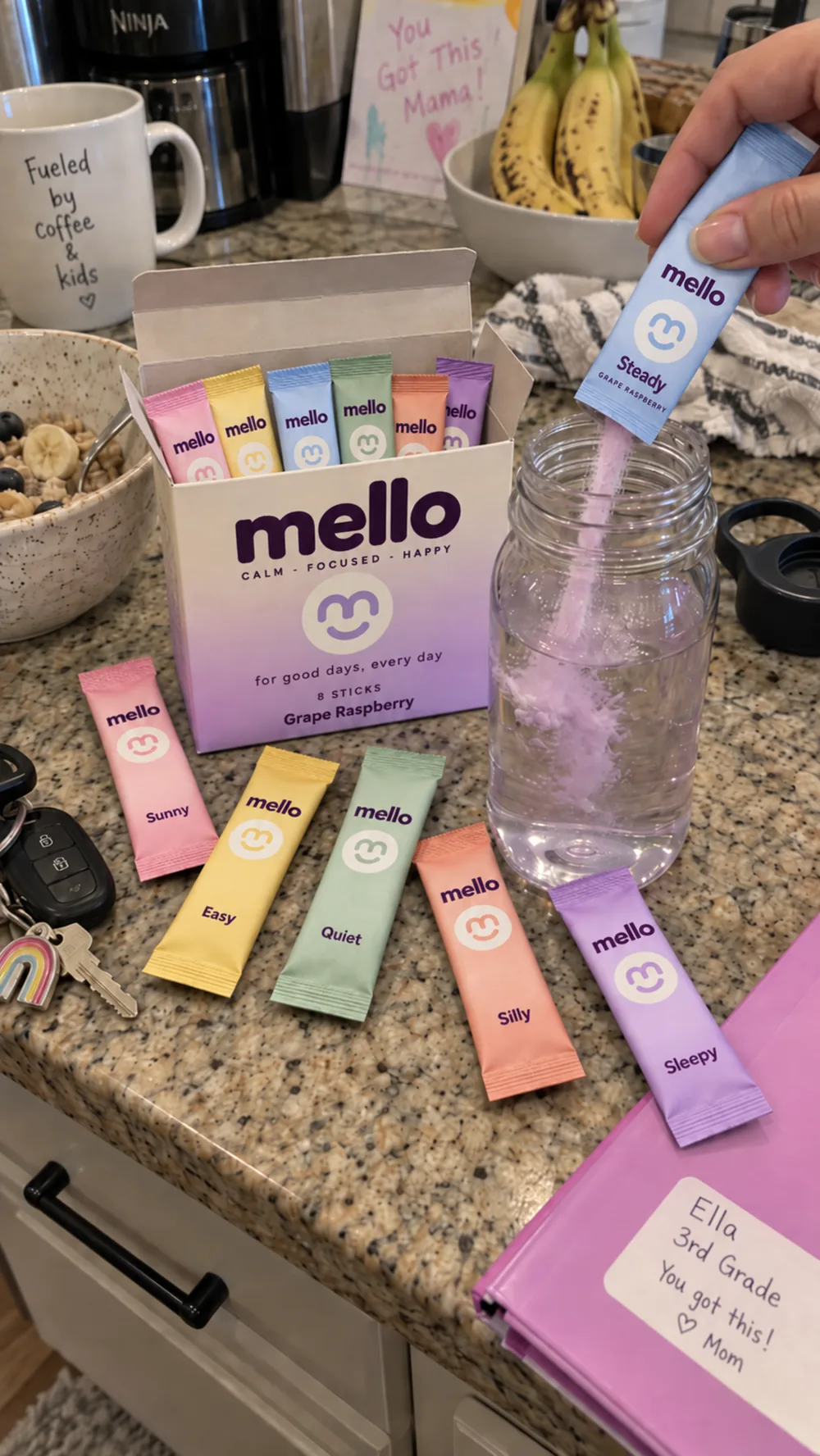 A real kitchen counter with the mello 8 count box open, the pastel mood sticks laid out across the granite and a hand pouring the Steady stick into a jar of water